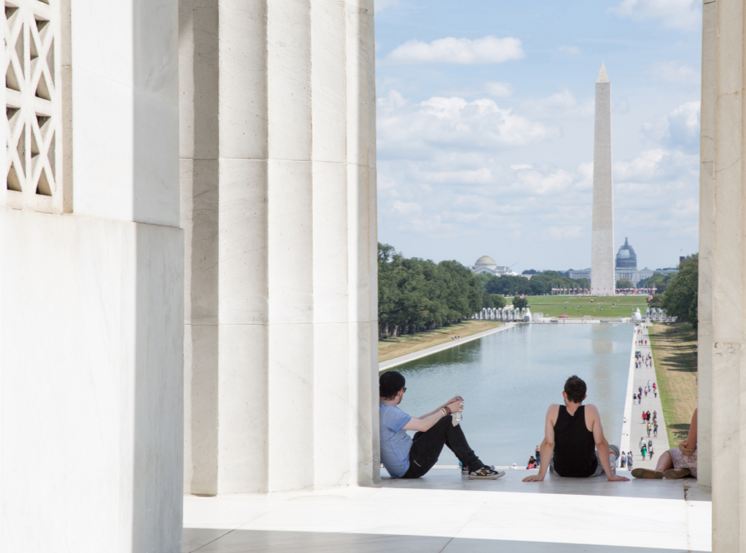 Students sitting at the Lincoln looking at the Washington monument
