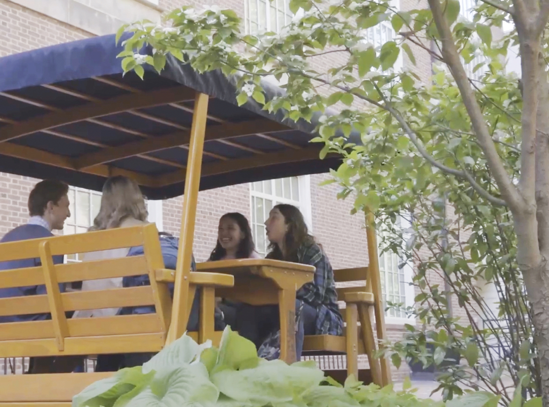 students talking at covered picnic table